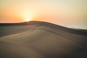 Fußspuren Im Sonnenuntergang einer Wüsten- und Dünenlandschaft in Dubai in den Vereinigten...