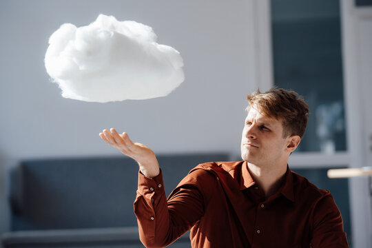 Businessman with levitating cloud network in office