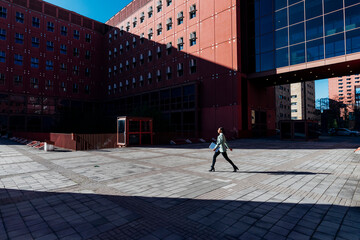 Businesswoman with laptop walking in office campus