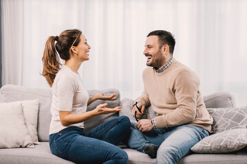 Happy couple chatting and smiling at each other at home.