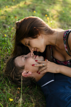 Smiling young woman embracing boyfriend lying on grass