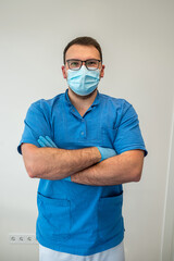 a professional young dentist in medical clothes is waiting for his patients.