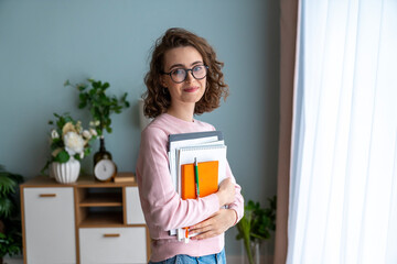 Smiling student with book in living room