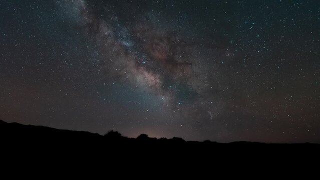 The center of the Milky Way Galaxy moving across the sky over the desert horizon - time lapse