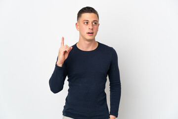 Young caucasian man isolated on white background thinking an idea pointing the finger up