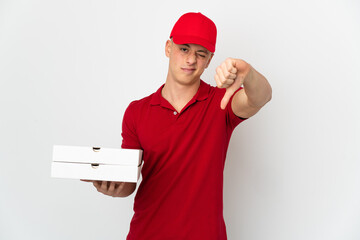 Pizza delivery man with work uniform picking up pizza boxes isolated on white background showing thumb down with negative expression