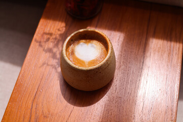 Obraz na płótnie Canvas Coffee cup with latte art on the wood table.