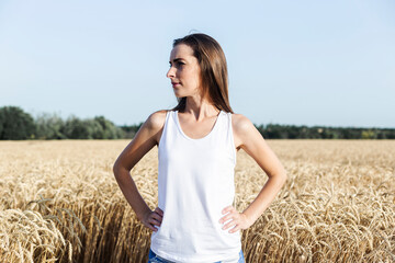 Young woman in a wheat field looks to the side