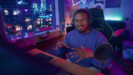 Excited African American Streamer Talking and Entertaining Followers During Live Broadcast Online. Stylish Black Man Streaming His Life and Personal News from Home Living Room Apartment.
