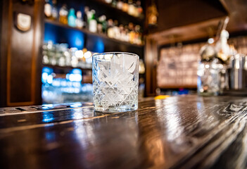 ice cube in an empty glass on a bar counter in bar or pub