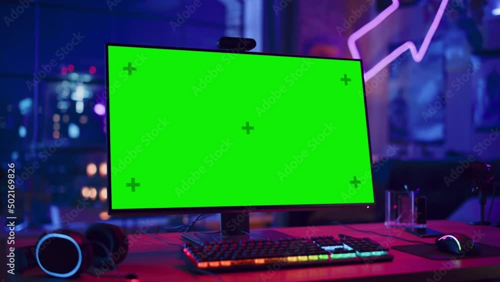 Poster gaming at home: empty gaming station with player's personal computer with green screen chroma key di