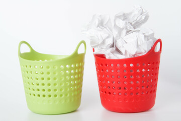 Two baskets. The green basket is empty - the red one is full. Crumpled paper in the trash can.