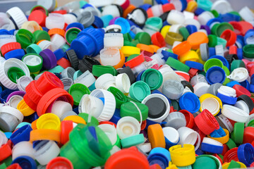 Lots of colorful plastic lids from bottles, discarded waste collected for recycling, environmental...