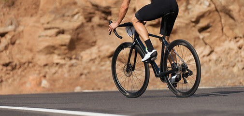 Road bike cyclist man cycling. Biking sports fitness athlete riding bike on an open road, active...