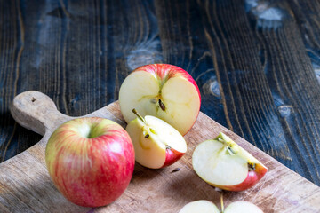 cutting old board with pieces of red ripe apple