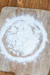 white wheat flour scattered on the table during cooking