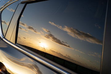 自動車の窓に反射する朝焼け