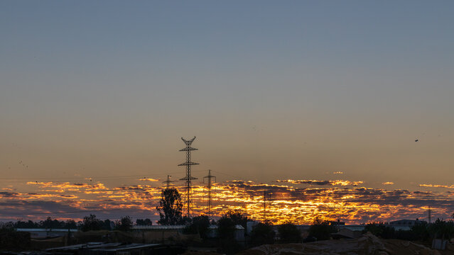 Power lines at golden sky background