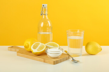 Fototapeta premium Composition with household cleaners on white table against yellow background