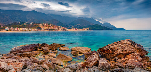 Panoramic morning view of Potam Public beach. Colorful summer seascape of Adriatic sea with Himare town on background, Albania, Europe. Traveling concept background.