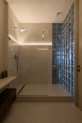 shower in the loft interior with glass blocks, modern loft style bathroom with shower, evening lighting in the interior