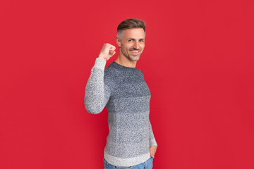 happy successful man in sweater on red background, success