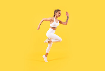 Fototapeta na wymiar fitness girl jumping in sportswear on yellow background