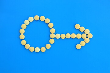 Male sign with yellow pills on a blue background.