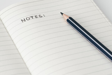 close-up view of pencil on page of notebook with word NOTES