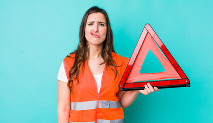young pretty woman  feeling sad and whiney with an unhappy look and crying. car emergency triangle