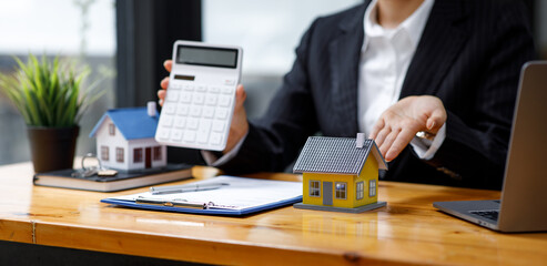 Mortgage loan Real estate broker agent presenting and consulting the customer to decision-making sign insurance form agreement, home model, concerning offer for and house insurance.