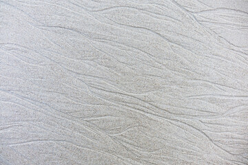 Sand background and texture. Wet beach sand texture after low tide. Sand with wave print. Ripple on...