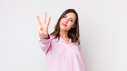 young pretty woman smiling and looking friendly, showing number three or third with hand forward,...