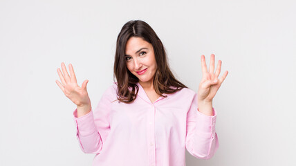 young pretty woman smiling and looking friendly, showing number nine or ninth with hand forward,...