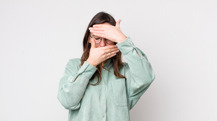 young pretty woman covering face with both hands saying no to the camera! refusing pictures or...