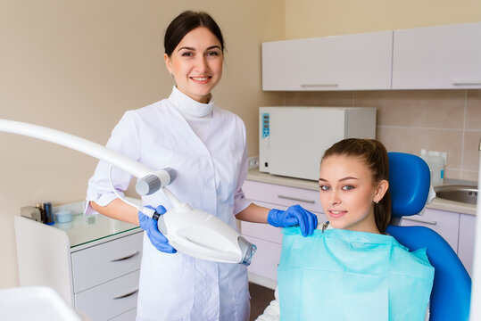 The girl smiles in dentistry. patient dentist racing model at the Dental Clinic. White well-groomed teeth after taking a doctor. Tooth whitening and tooth enamel