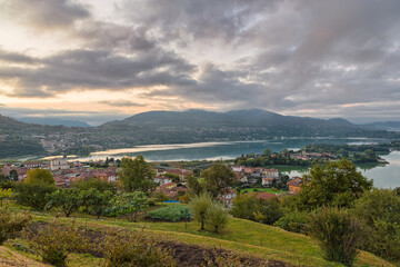 Fototapeta na wymiar Beautiful Italian lake at sunrise. Aerial view of lake Annone or lake Oggiono with Civate in the foreground and in the background the section between towns of Sala Al Barro and Oggiono