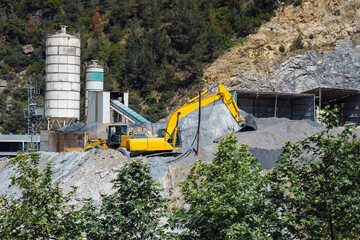 Excavator in the mining industry near mountains