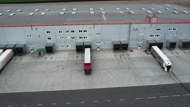 Cargo truck with a trailer is parked in reverse near a huge logistics center to unload or unload goods. Concept of Logistics, Transport, Cargo Transportation, Delivery. High quality 4k footage