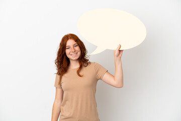 Teenager redhead girl isolated on white background holding an empty speech bubble