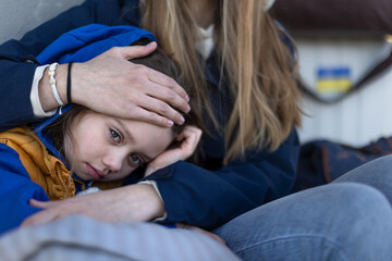 Depressed Ukrainian immigrants sitting and waiting at railway station.