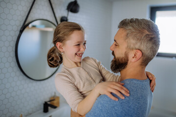 Father having fun with his little daughter in bathroom.