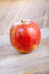 red ripe apple on a wooden chopping board