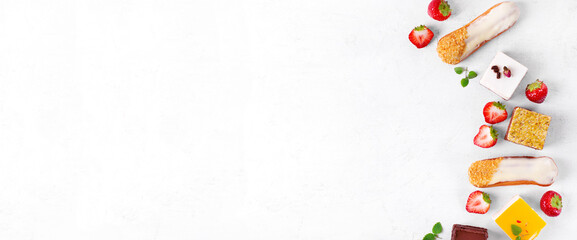 Web banner with cakes assortment. Dessert variation on the white table: Eclairs, mousse cake with...