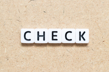 White tile alphabet letter with word check on wood background