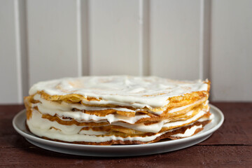 Pancakes with sour cream on a white plate