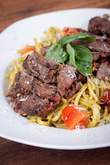 Grilled flank steak over basil pesto keto pasta