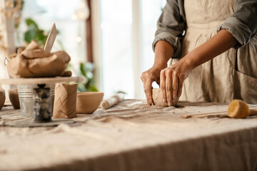 Young black ceramist woman sculpting in clay at her workshop