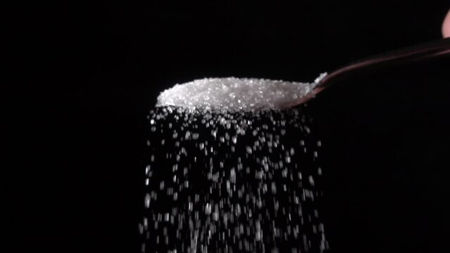sprinkling sugar from a spoon, slow motion 10x