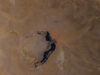 Landscape of Iceland. inactive crater from above. brown sand surface of Reykjanes Peninsula. Shadows and reddish coloring at the rim of the crater when there is sunshine during the day